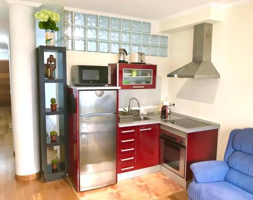 a small kitchen with a refrigerator and a microwave at Apartamento Centro Histórico in Pontevedra