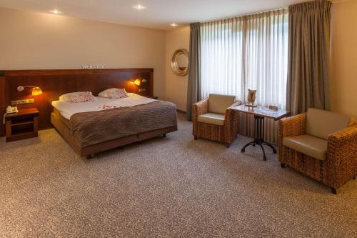 a hotel room with a bed and two chairs at Best Western Hotel Nobis Eindhoven-Venlo A67 in Asten
