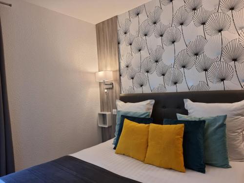 a bedroom with a bed with a painting on the wall at City Loft Apparthotel in Dijon