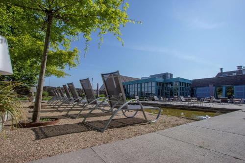 a row of empty chairs sitting in a park at Best Western Hotel Nobis Eindhoven-Venlo A67 in Asten