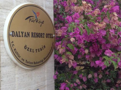 a sign for a dalyan resort outpost with purple flowers at Dalyan Resort - Special Category in Dalyan