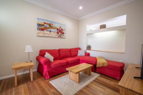 a living room with a red couch and a table at Kernow - Minimum age 18 in Charters Towers
