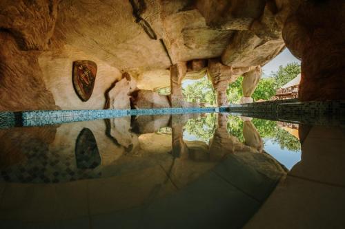 a reflection of a giraffe in a pool of water at Etno hotel Balasevic Rtanj in Boljevac