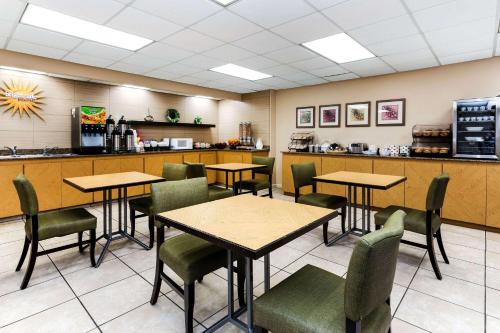 a restaurant with tables and chairs and a counter at La Quinta by Wyndham St. Pete-Clearwater Airport in Clearwater