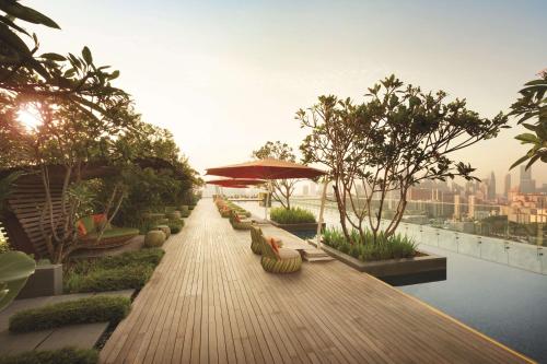 a wooden walkway with benches and an umbrella on a building at JEN Singapore Orchardgateway by Shangri-La in Singapore