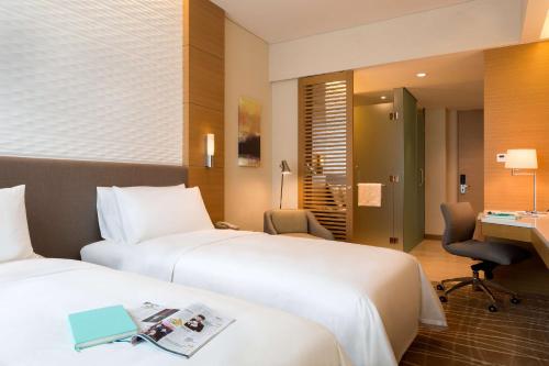 
a hotel room with two beds and a television at JEN Singapore Orchardgateway by Shangri-La - SG Clean in Singapore

