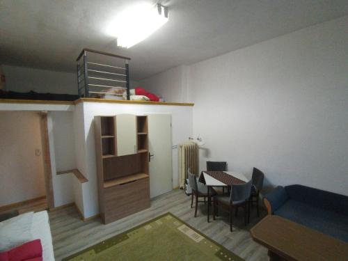 a living room with a table and a room with a staircase at LINDENHOF WALDHEIM in Waldheim
