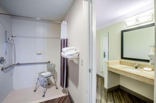 a bathroom with a shower and a sink and a stool at La Quinta by Wyndham Houston Baytown East in Baytown