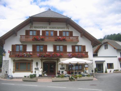 a building with a woman standing in front of it at Gasthof Karlwirt in Sankt Andrä im Lungau