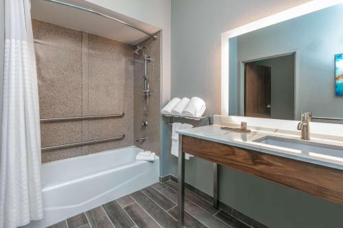 a bathroom with a sink and a tub and a shower at La Quinta by Wyndham Jacksonville, Texas in Jacksonville