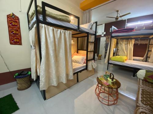 Jawai Bagpackers Hostel في Sheoganj: غرفة بسريرين بطابقين وطاولة