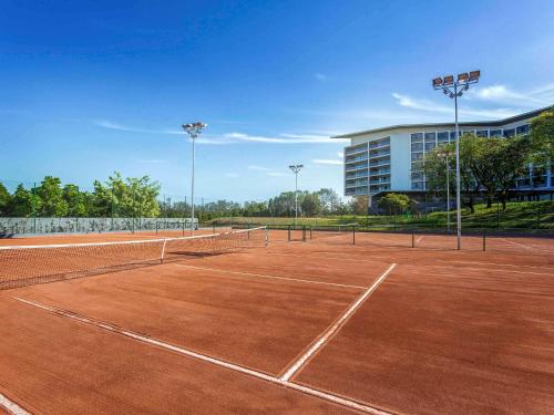 a tennis court in front of a building at Novotel Itu Terras de São José Golf & Resort in Itu