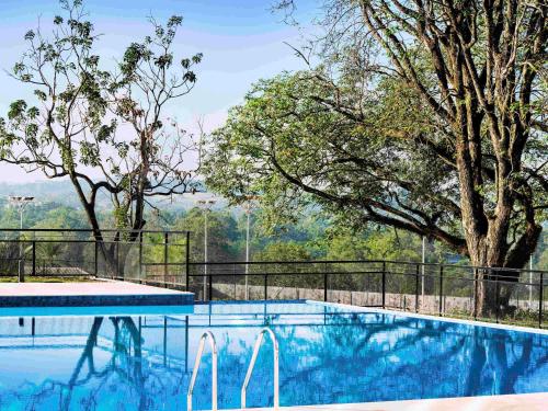 a swimming pool with a view of some trees at Novotel Itu Terras de São José Golf & Resort in Itu