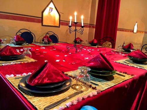 a red table with red napkins on a red table cloth at Kasbah Tiriguioute in Skoura