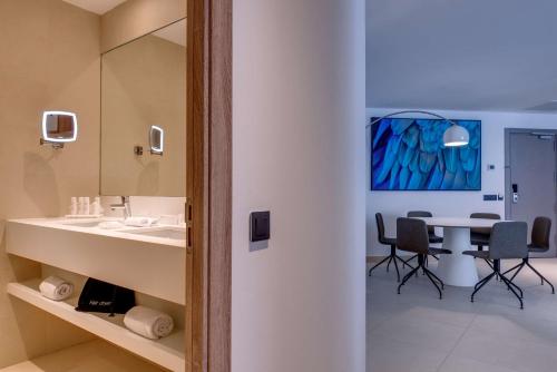 a room with a table, chairs, and a mirror at Radisson Blu Resort & Spa, Gran Canaria Mogan in Puerto de Mogán