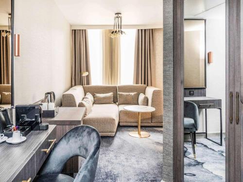 a living room with a couch and a table at Novotel Leicester in Leicester