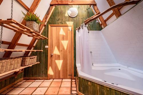 a bathroom with a large tub and a wooden ceiling at Currawong - Freycinet Holiday Houses in Coles Bay