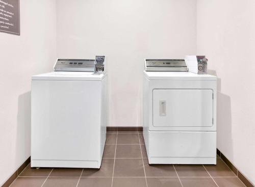 two washing machines and a washer and dryer in a room at Wingate by Wyndham Longview North in Longview