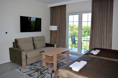 a hotel room with a couch and a table at Przystanek Natura in Wola Gardzienicka
