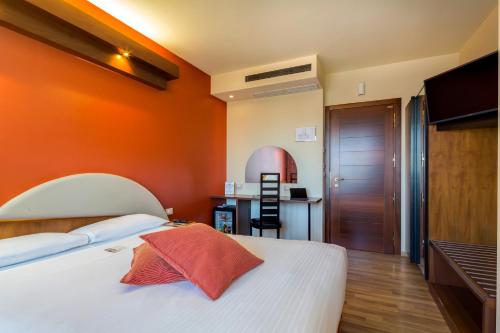 a bedroom with an orange wall and a bed at La Villa - Sure Hotel Collection by Best Western in Ivrea