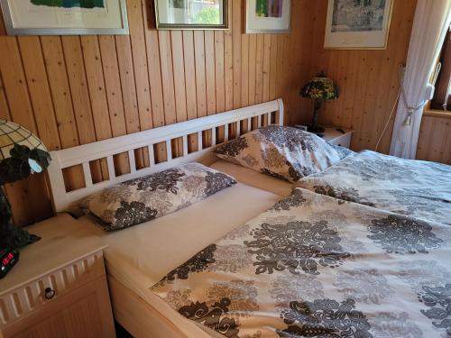two beds in a room with wooden walls at Ferienhaus Lefering Stiftung in Otterndorf