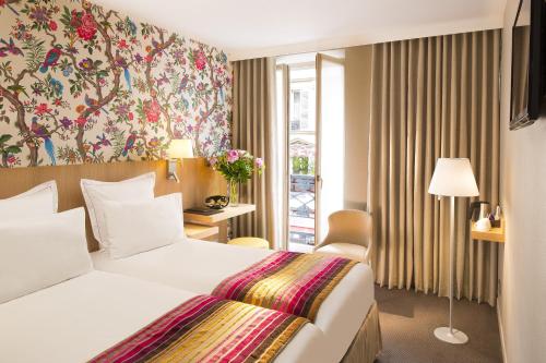 une chambre d'hôtel avec un lit et une fenêtre dans l'établissement Hôtel Cordelia Opéra-Madeleine, à Paris