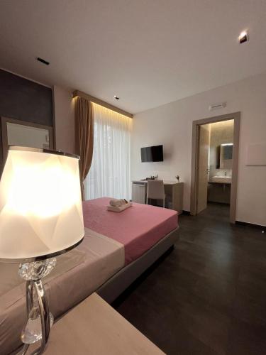 a hotel room with a bed and a lamp at B&B Margherita in Messina