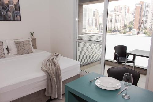 a small room with a bed and a table with a glass of wine at 360 Perdizes in Sao Paulo