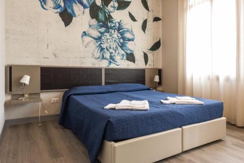 a bedroom with a blue bed with towels on it at Albergo Leon D'Oro in Maniago