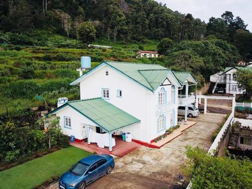 a car parked in front of a white house at Vibe way (Hostel & Market farm) in Nuwara Eliya