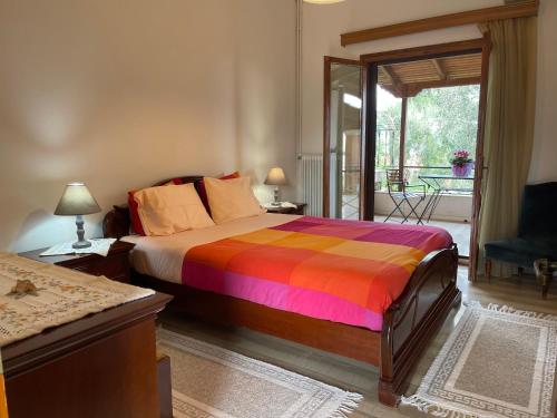 a bedroom with a bed with a colorful blanket at Villa Evita Corfu in Dassia