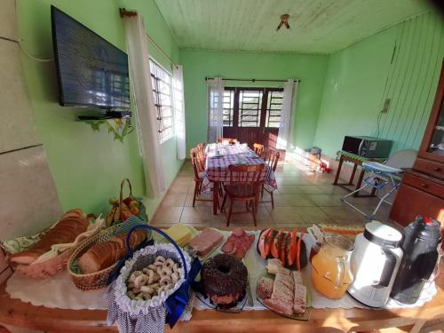 a living room with a table and a dining room at Pousada Rural Capão das Vertentes in Cambará