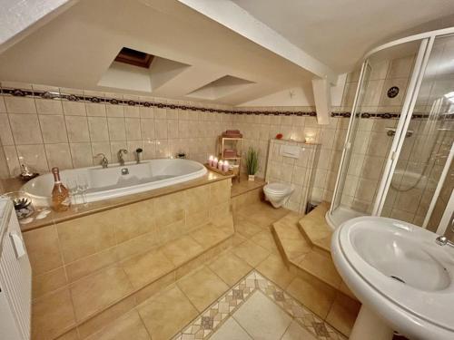 a bathroom with a tub and a toilet and a sink at Ferienwohnung Alte Feuerwehr in Ueckermünde