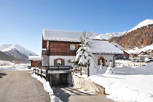 a house is covered in snow with a driveway at Baita sulle Alpi Livigno in Livigno