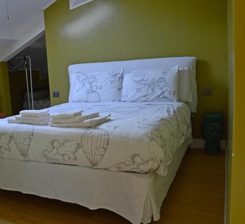 a bed with a white comforter and pillows at B&B Via Roma 41 in Ventimiglia