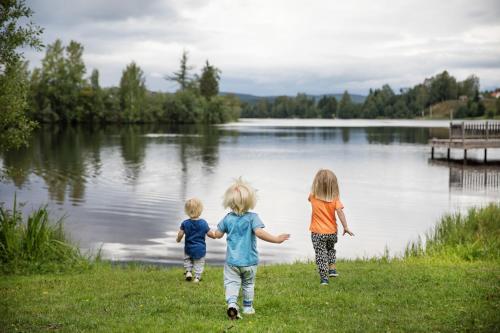 a group of three children walking by a lake at First Camp Mellsta-Borlänge in Borlänge