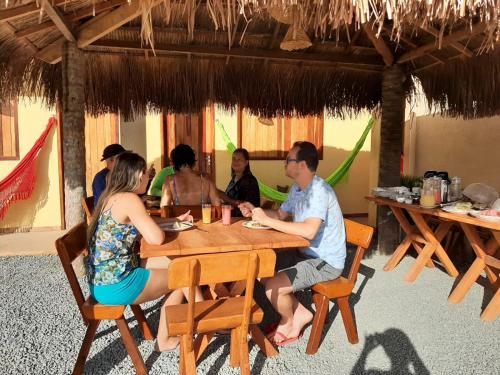a group of people sitting at a table in a restaurant at Pousada Milagres do Embaúba in São Miguel dos Milagres