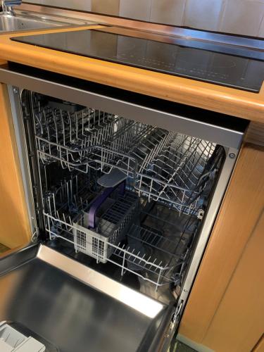 a dishwasher with a dish rack inside of it at La Casa di Carmen in Tarvisio