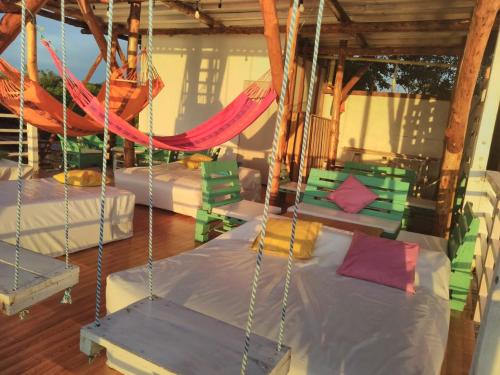 a room with two beds and a hammock at posada donde Uriel Playa tranquila in Baru