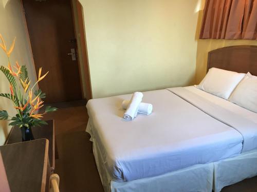 a hotel room with a bed with a roll on it at Hotel Millenium in Labuan