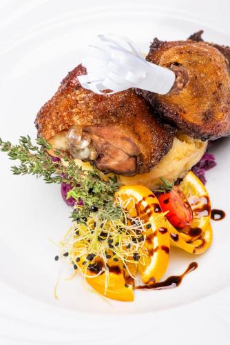 a plate of food with a chicken and vegetables at Gastland M0 Hotel & Conference Center in Szigetszentmiklós
