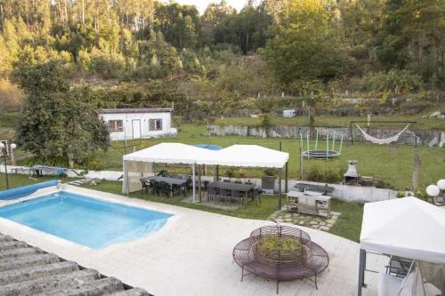 a backyard with a swimming pool with a table and chairs at Quintinha de Sabadim - 500 metros da ecovia de Sistelo in Arcos de Valdevez