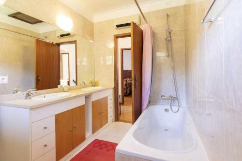 Un baño con bañera, lavabo y ducha. en Quintinha de Sabadim - 500 metros da ecovia de Sistelo, en Arcos de Valdevez