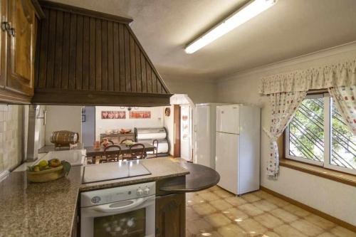 a kitchen with a stove and a refrigerator at Quintinha de Sabadim - 500 metros da ecovia de Sistelo in Arcos de Valdevez
