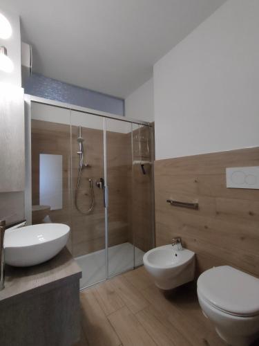 a bathroom with a shower and a toilet and a sink at Appartamenti La Val in Andalo