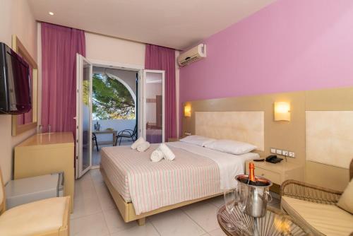 a hotel room with a bed and a living room at Porto Koukla Beach in Lithakia