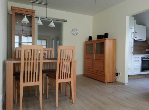 a dining room with a table and chairs and a kitchen at Ferienwohnungen Haus Elena 45241 in Ditzum