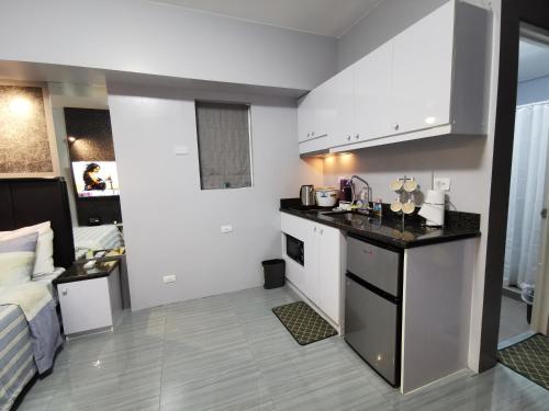 a kitchen with white cabinets and a counter top at Avida Davao by davaobnb & Lemonique Homes in Davao City