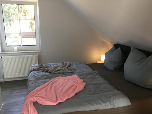 a bed with a pink sheet on it in a bedroom at Apartment Marit in Norden