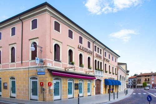a pink building on the side of a street at Albergo Leon D'Oro in Maniago